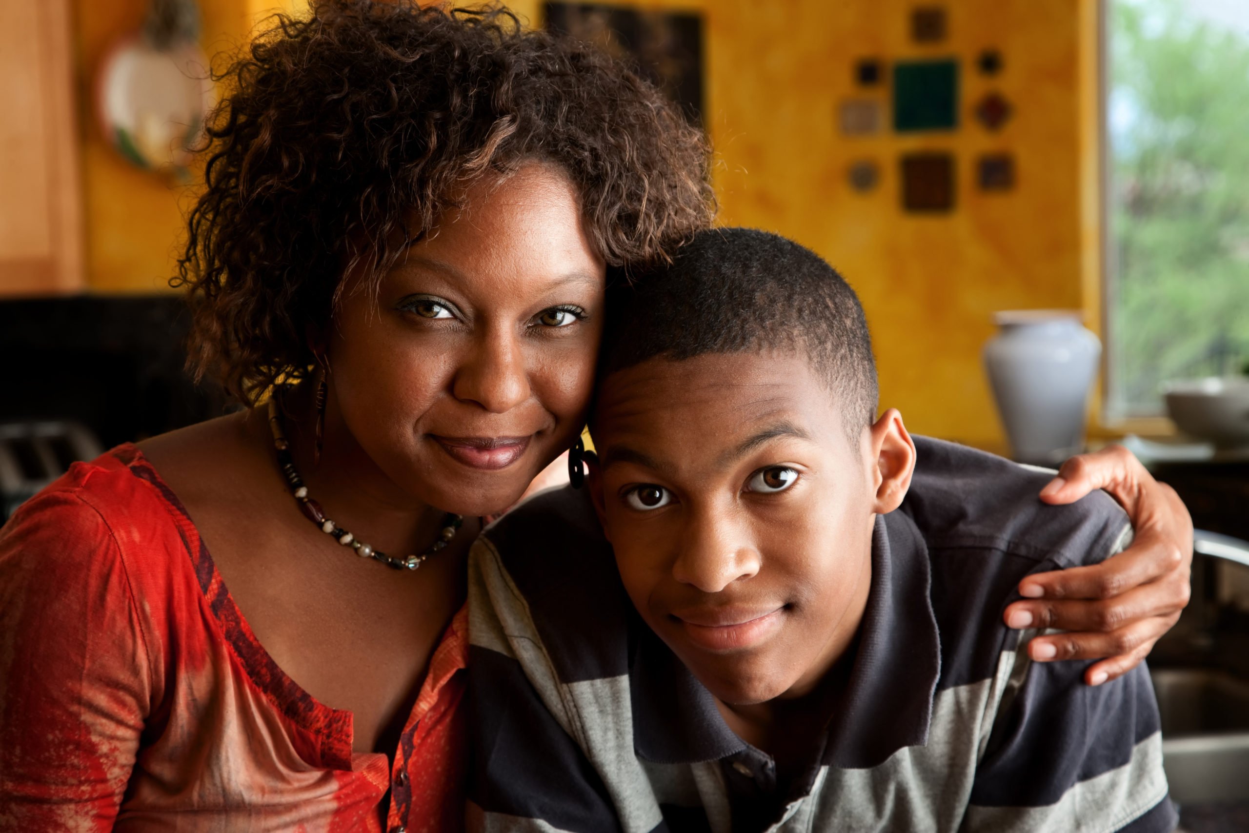 african-american-mother-holding-son-and-smiling